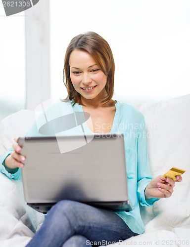 Image of smiling woman with laptop computer at home