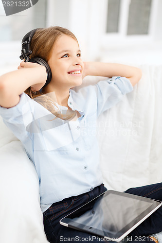 Image of girl with tablet pc and headphones at home
