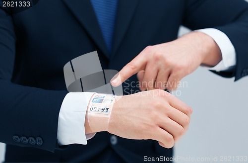 Image of businessman pointing to something at his hand