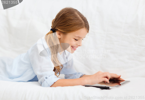 Image of smiling girl with tablet computer at home