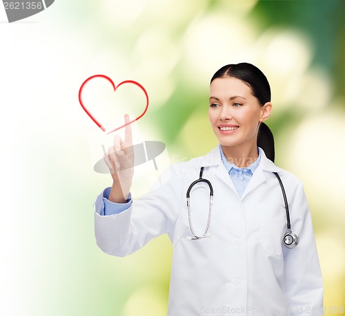 Image of smiling female doctor pointing to heart