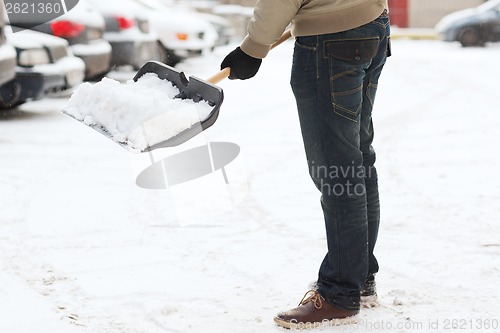 Image of closeup of man shoveling snow from driveway