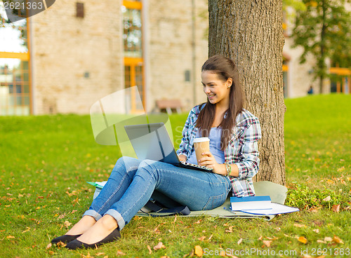 Image of teenager in eyeglasses with laptop and coffee