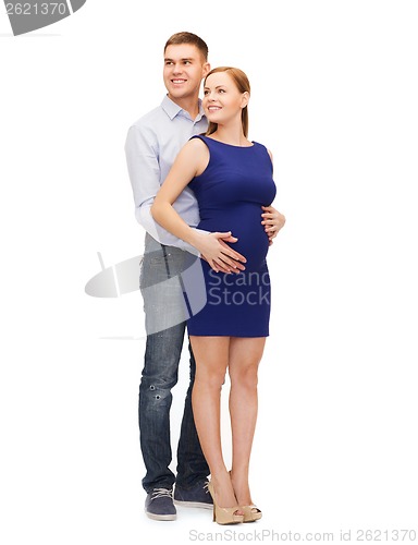 Image of happy young family expecting child looking up