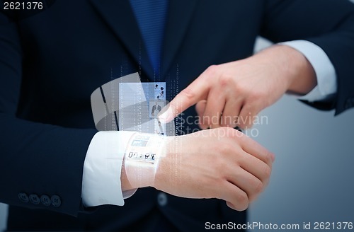 Image of businessman pointing to something at his hand