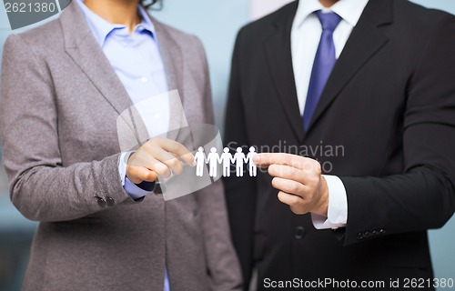 Image of businessman and businesswoman holding paper team