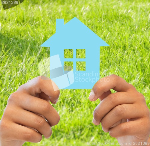 Image of woman hands holding blue house