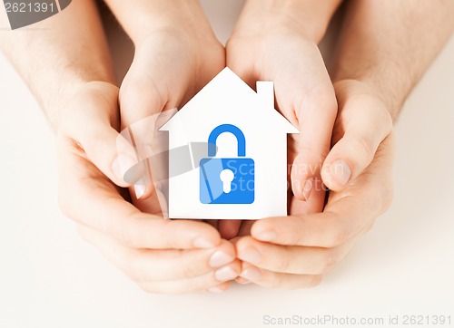 Image of hands holding paper house with lock