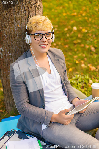 Image of smiling male student in eyeglasses with tablet pc