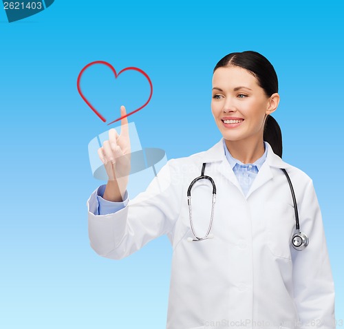 Image of smiling female doctor pointing to heart