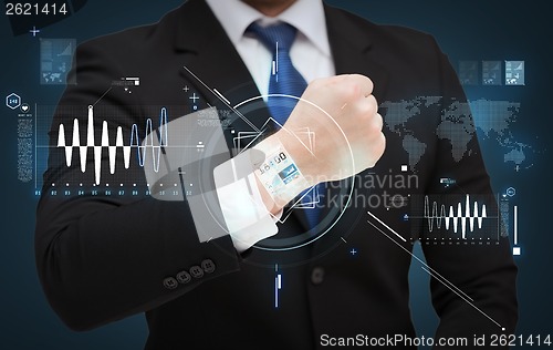 Image of businessman showing something at his hand
