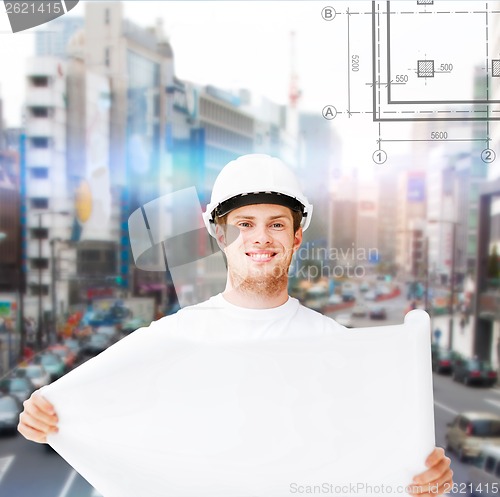 Image of male architect in helmet with blueprint