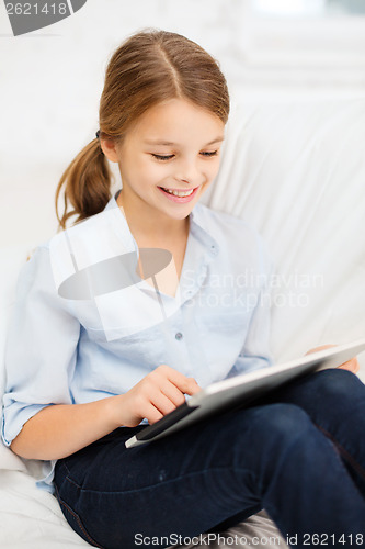 Image of smiling girl with tablet computer at home