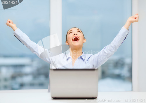 Image of screaming businesswoman with laptop in office