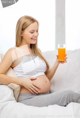 Image of happy pregnant woman with fresh orange juice