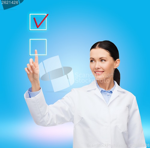 Image of smiling female doctor pointing to checkbox
