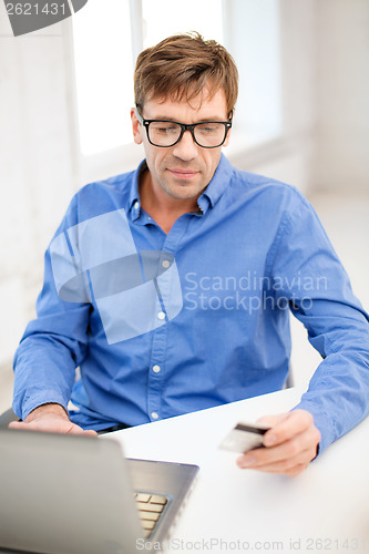 Image of man with laptop and credit card at home