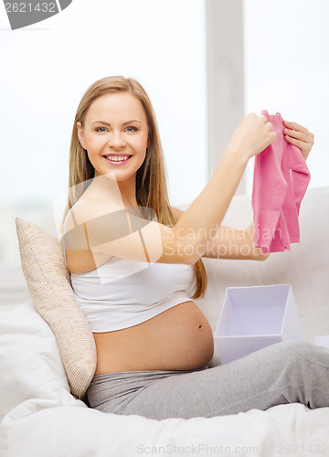 Image of smiling pregnant woman opening gift box