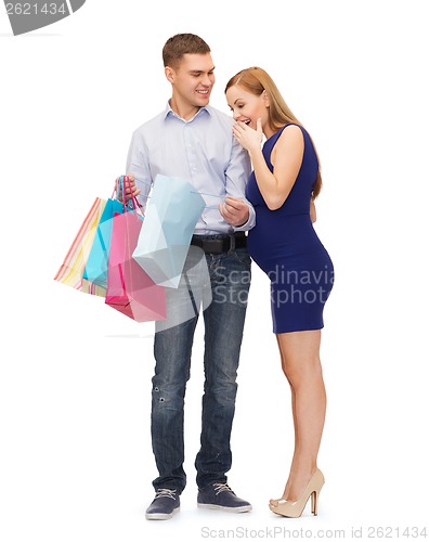 Image of happy family expecting child with shopping bags