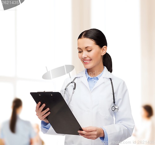 Image of smiling female doctor with clipboard