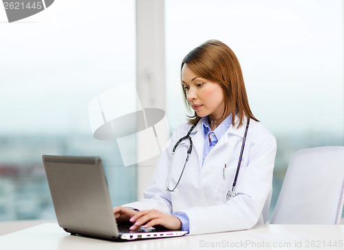 Image of busy doctor with laptop computer