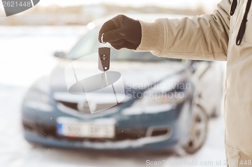 Image of closeup of man hand with car key outdoors