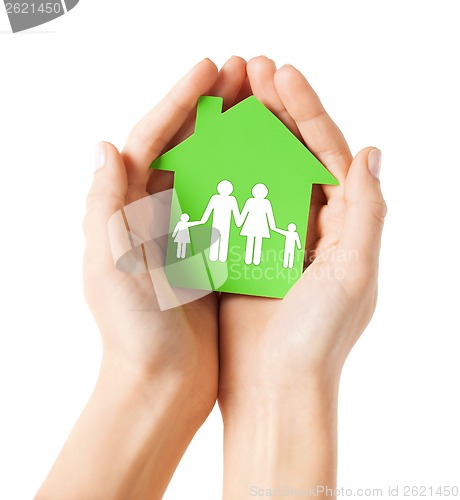 Image of hands holding green house with family