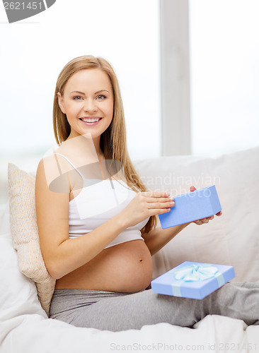 Image of smiling pregnant woman opening gift box