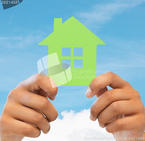 Image of woman hands holding green house