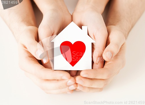 Image of couple hands holding white paper house