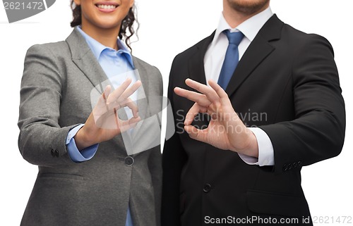 Image of businessman and businesswoman showing ok sign