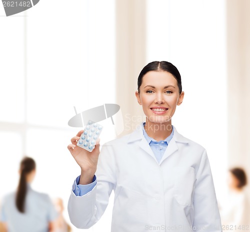 Image of smiling female doctor with pills