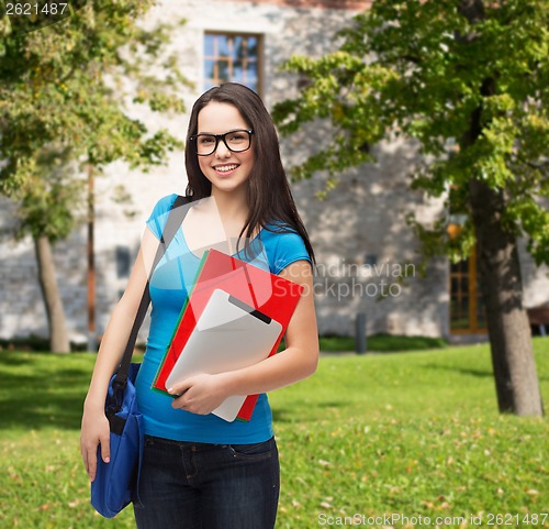 Image of smiling student with bag, folders and tablet pc