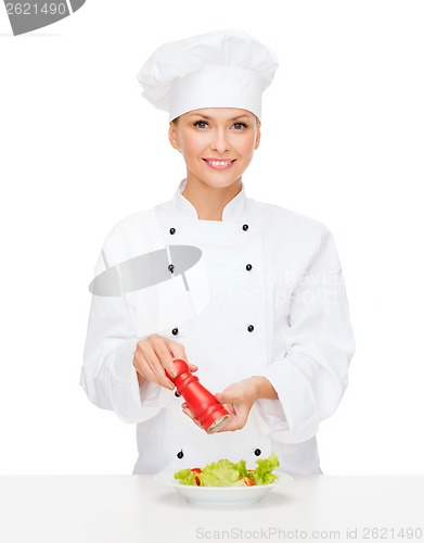Image of smiling female chef with preparing salad