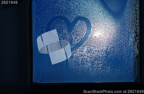 Image of Moonlight through the window. Sweaty glass and heart