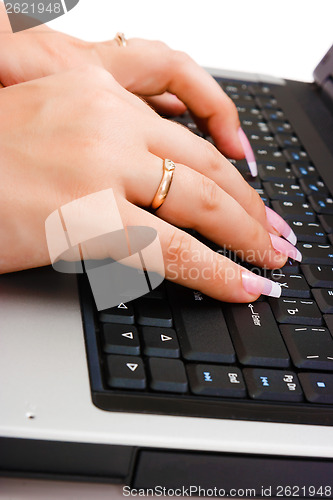 Image of Women's hand writing on a laptop keyboard