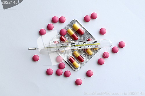 Image of High temperature on a thermometer, pills and tablets.