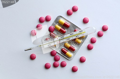 Image of High temperature on a thermometer, pills and tablets.