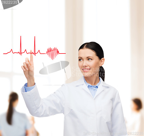 Image of smiling female doctor pointing to cardiogram