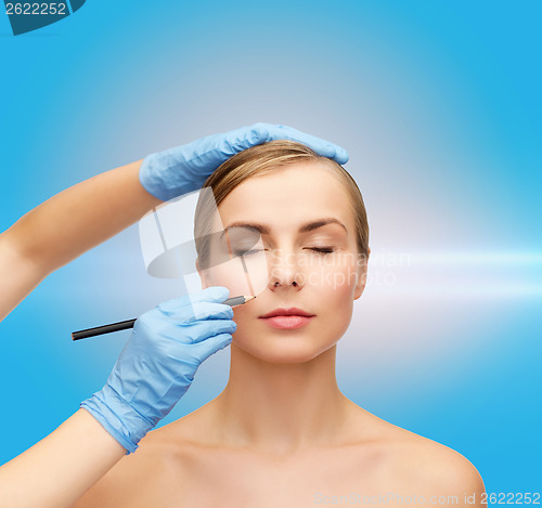 Image of woman face and beautician hands with pencil