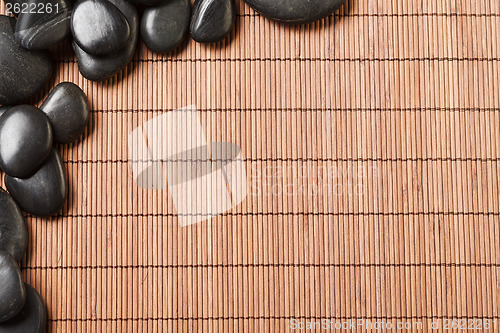 Image of massage stones on bamboo mat