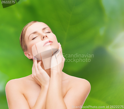 Image of beautiful woman touching her face with closed eyes