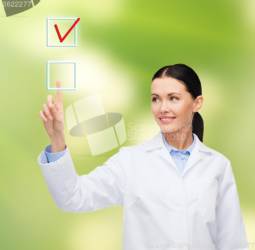 Image of smiling female doctor pointing to checkbox