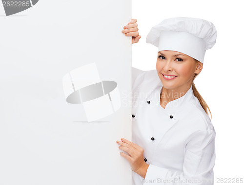 Image of smiling female chef with white blank board