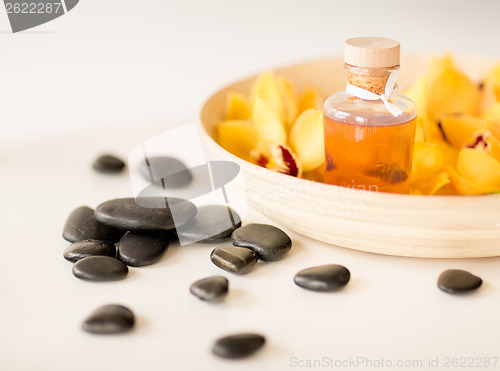 Image of massage stones with flowers on table