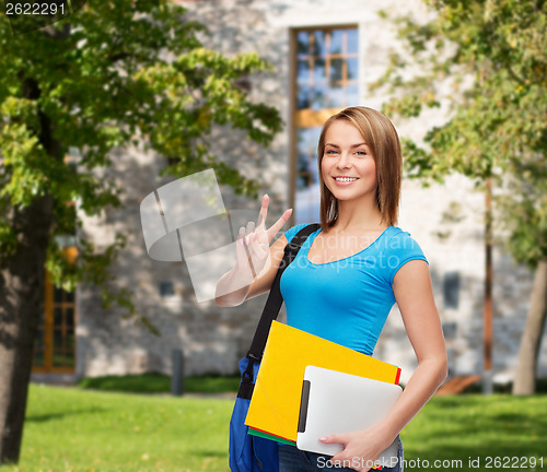 Image of female student with bag, tablet pc and folders