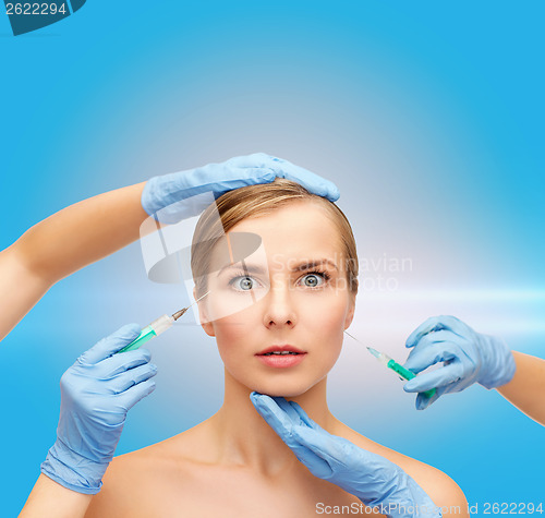 Image of woman face and beautician hands with syringe