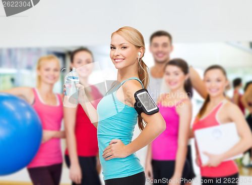 Image of sporty woman running with smartphone and earphones