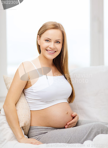 Image of happy pregnant woman touching her belly