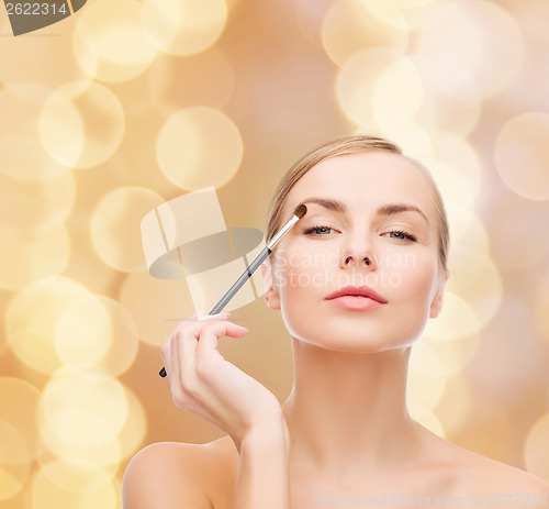 Image of beautiful woman with makeup brush